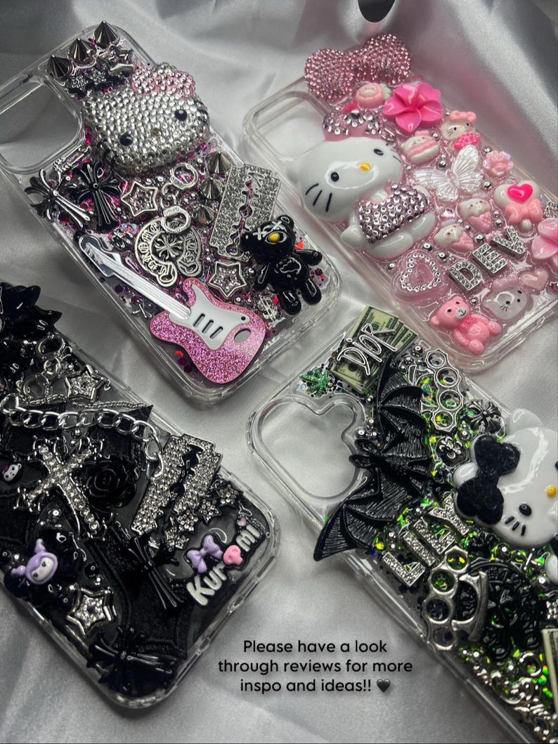 May include: Four clear phone cases with decorative embellishments. One case features a bedazzled Hello Kitty, another has a black teddy bear and a pink guitar. The third case has a black bat and a Hello Kitty. The fourth case has a black bow and the word "Kuromi".