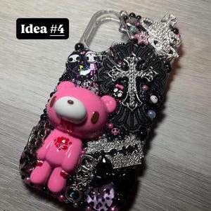 May include: A bedazzled phone case with a pink, cartoon bear figure with blood details. The case is decorated with black beads, a silver cross, and a silver razor blade. The text "Idea #4" is in a black rectangle.