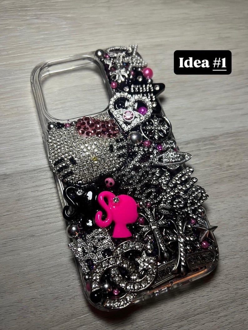 May include: Clear phone case bedazzled with rhinestones, silver embellishments, and pink accents. Features a pink silhouette and the text "Idea #1". The case is decorated with various charms and jewels.