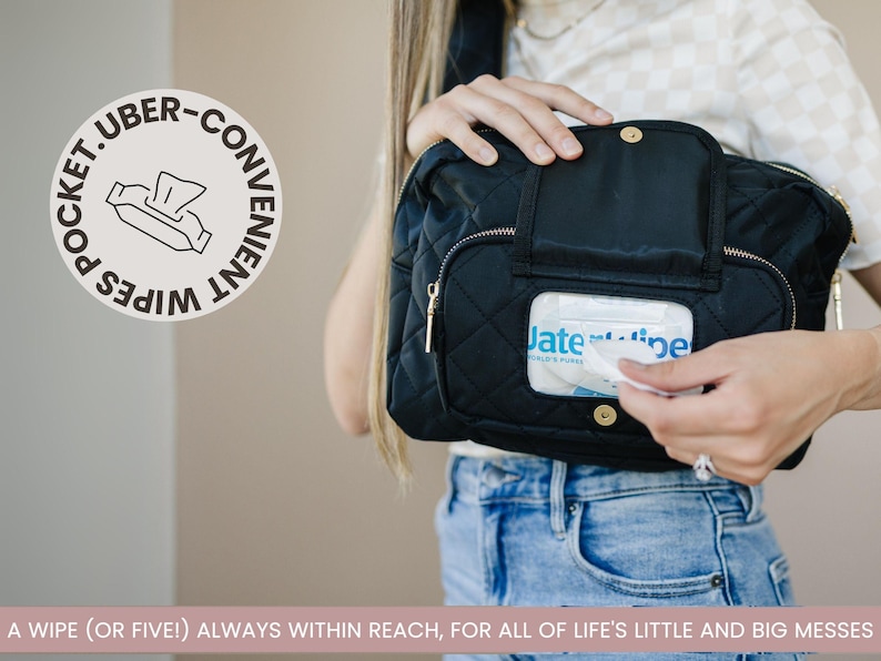Mom wearing black Jetsetter Mini crossbody diaper bag with easy-access wipes pocket.
