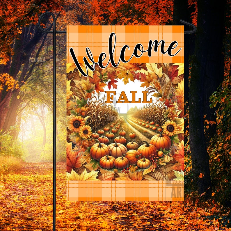 K&ouml;nnte beinhalten: Eine Herbst-Gartenflagge mit einem orange-wei&szlig; karierten Hintergrund. Die Flagge zeigt einen Kranz aus Herbstbl&auml;ttern mit dem Wort "Herbst" in der Mitte. Der Kranz umgibt einen Weg, der mit K&uuml;rbissen und Maisst&auml;ngeln ges&auml;umt ist.