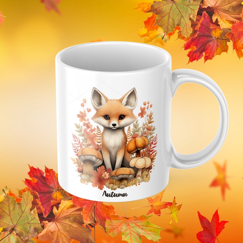 May include: White ceramic mug with a cartoon fox sitting on mushrooms and surrounded by autumn leaves. The mug has the word "Autumn" printed on the bottom.