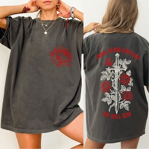 May include: A dark gray oversized t-shirt with a red rose graphic on the front and a red rose and sword graphic on the back. The back graphic says "From Blood and Ash We Will Rise".
