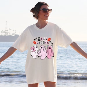 a woman standing on the beach with her arms out