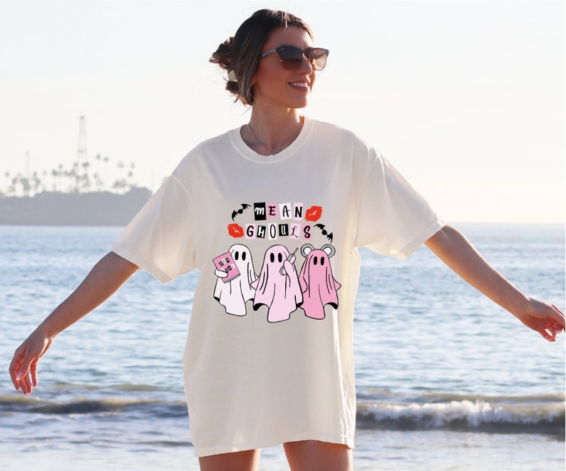 a woman standing on the beach with her arms out