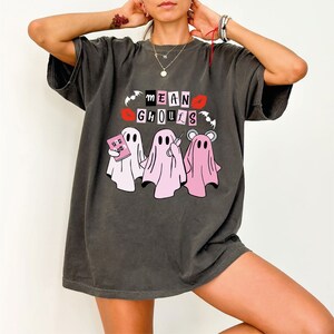 a woman wearing a t - shirt with a group of ghost on it