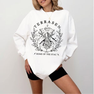 a woman wearing a white sweatshirt and black shorts