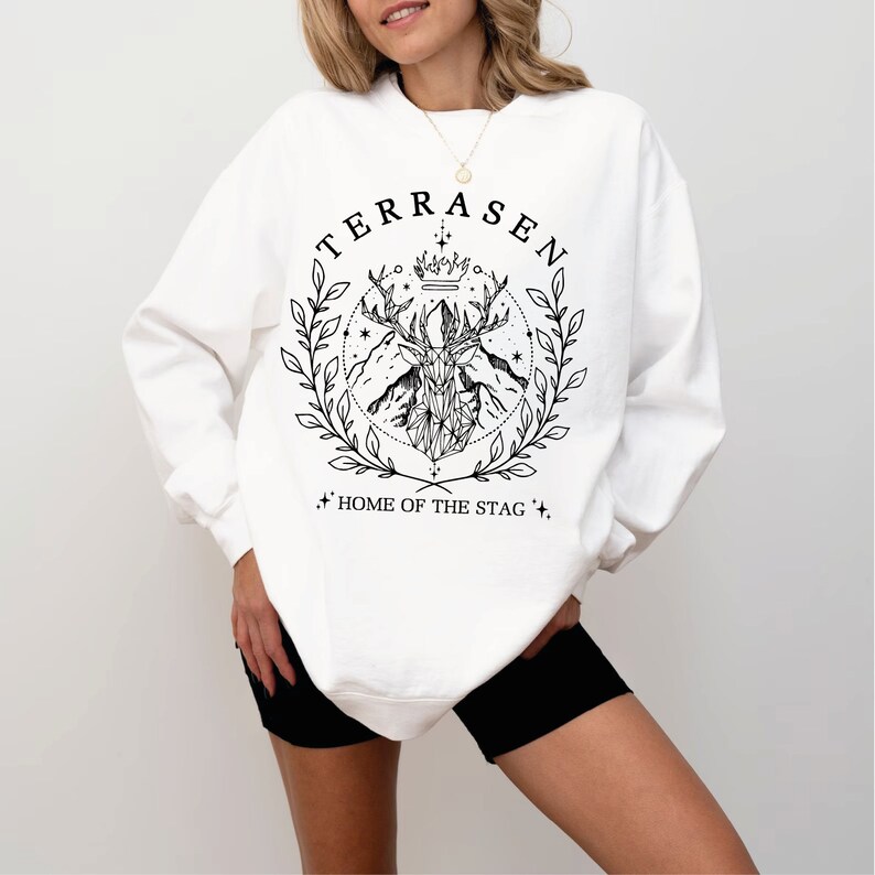 a woman wearing a white sweatshirt and black shorts