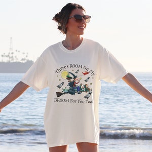 a woman standing on the beach with her arms outstretched
