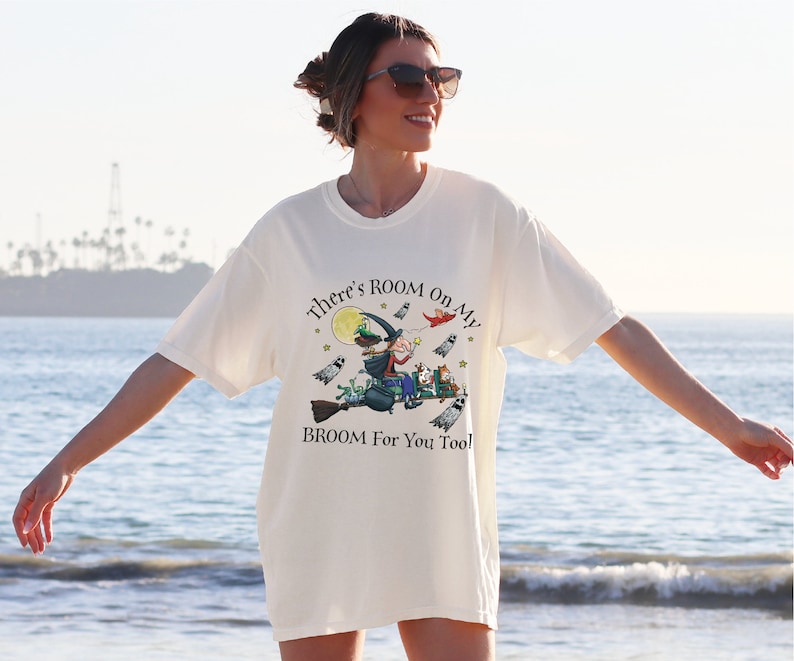 a woman standing on the beach with her arms outstretched