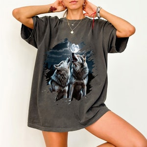a woman wearing a t - shirt with two wolfs on it