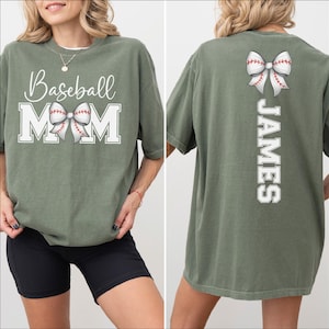 A woman wearing a green t-shirt with the text "Baseball Mom" printed on it, along with a bow on the back.