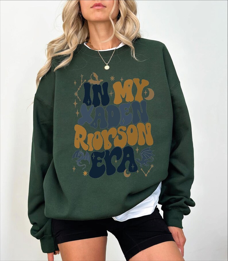 a woman wearing a green sweatshirt and black shorts