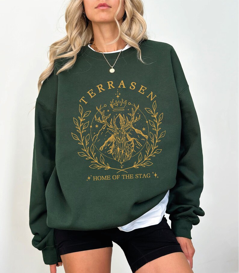 a woman wearing a green sweatshirt and black shorts