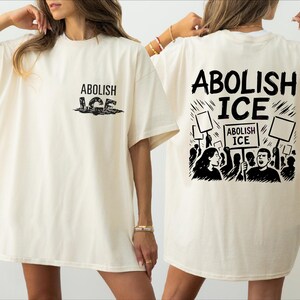 two women wearing t - shirts that say abollish ice
