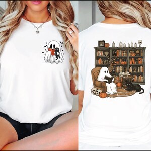 The image is a collage of two photos. The left photo shows a woman wearing a white t-shirt with a ghost and a cat on the front, and the right photo shows a woman wearing a white t-shirt with a ghost and a cat on the back.