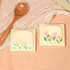 May include: A handmade wooden sign with the text "Welcome" in a handwritten style. The sign is painted white with a distressed finish, and a small, decorative heart is attached. The sign is designed for indoor or outdoor use.