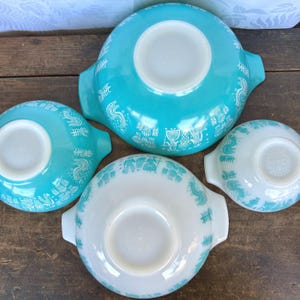 May include: Set of four vintage turquoise and white mixing bowls with a rooster and floral design. The bowls are nested inside each other.