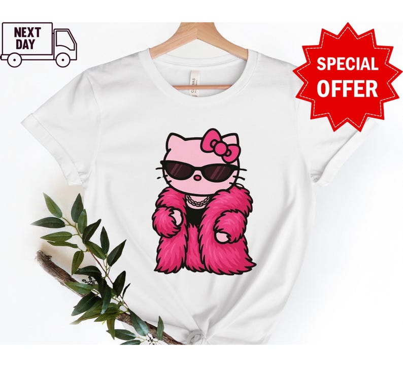 Puede incluir: Camiseta blanca con un gato de dibujos animados rosa con gafas de sol y un abrigo de piel rosa. El gato tiene un lazo rosa y un collar. La camiseta tiene el texto "NEXT DAY" y un icono de cami&oacute;n.