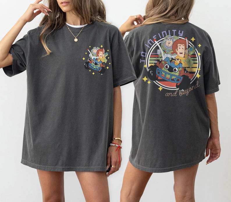Op de afbeelding: Donkergrijs t-shirt met een kleurrijke afbeelding van stripfiguren in een raceauto, met de tekst "To Infinity and Beyond" op de achterkant. De voorkant van de shirt heeft een kleinere versie van de afbeelding. Een casual, comfortabel t-shirt.