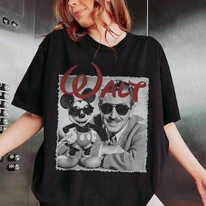 May include: Black t-shirt featuring a vintage-style graphic of Mickey Mouse and Walt Disney wearing sunglasses. The word "Walt" is printed in red above the image. The shirt is a classic crew neck.