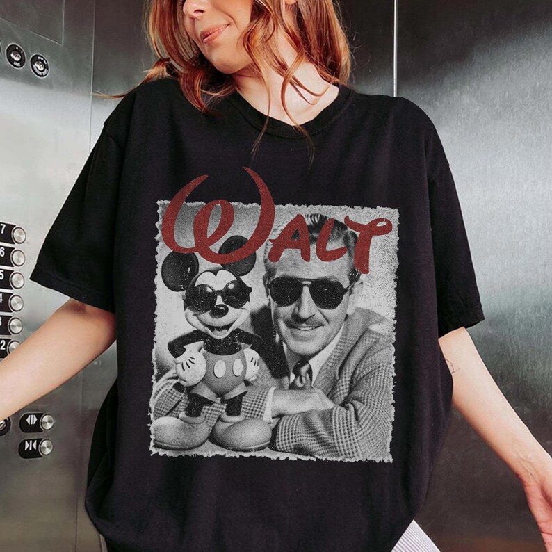 May include: Black t-shirt featuring a vintage-style graphic of Mickey Mouse and Walt Disney wearing sunglasses. The word "Walt" is printed in red above the image. The shirt is a classic crew neck.