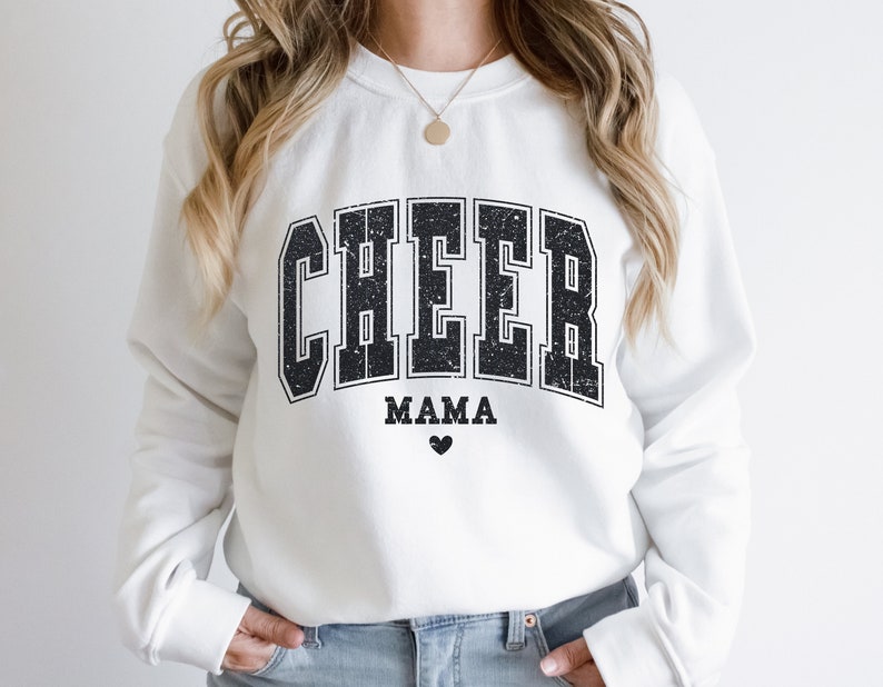 May include: White sweatshirt with black text that reads "CHEER MAMA" with a small black heart below the text.