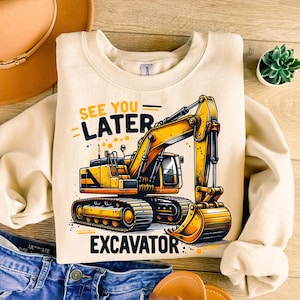 May include: A beige sweatshirt with a yellow excavator graphic and the text "See you later Excavator".