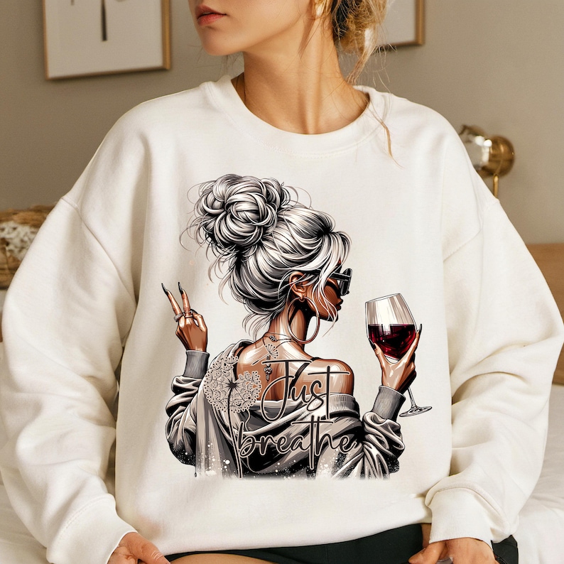 Peut inclure: Sweat-shirt blanc avec un motif repr&eacute;sentant une femme tenant un verre de vin rouge et le texte "Just Breathe".