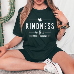 May include: A black t-shirt with white text that reads "KINDNESS is free - SPRINKLE IT EVERYWHERE" with a small heart graphic.