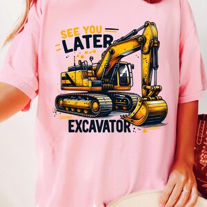 May include: Pink t-shirt with a yellow excavator graphic and the text "See You Later Excavator".