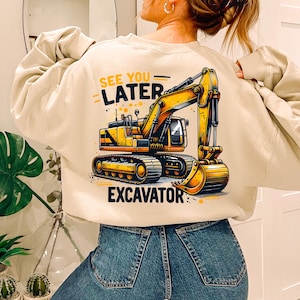 May include: A beige sweatshirt with a yellow excavator graphic and the text "See You Later Excavator".