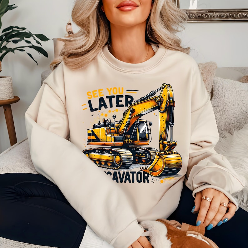 May include: A cream-colored sweatshirt with a yellow excavator graphic and the text "See You Later Excavator".