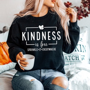 May include: Black sweatshirt with white text that reads "Kindness is free - Sprinkle it everywhere" with a small heart graphic.