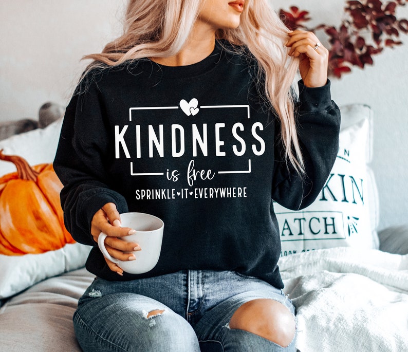 May include: Black sweatshirt with white text that reads "Kindness is free - Sprinkle it everywhere" with a small heart graphic.