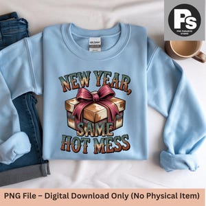 May include: A light blue sweatshirt with the text "NEW YEAR, SAME HOT MESS" in a vintage style. The graphic features a gift box with a pink bow. The sweatshirt is made of a soft material and is perfect for casual wear.