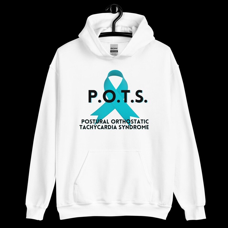 Pode incluir: Moletom branco com um gr&aacute;fico de fita azul-turquesa e a sigla "P.O.T.S." acima das palavras "Postural Orthostatic Tachycardia Syndrome" em preto. O moletom est&aacute; pendurado em um cabide preto.