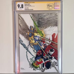 以下が含まれることがあります： 保護ケースに入った、評価9.8のコミック「Spawn #298」。表紙には、Spawnと他のキャラクターが躍動的に描かれたイラストがあり、鮮やかな色使いと細部までこだわった線画が特徴です。トッド・マクファーレンのサイン入りです。