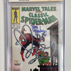 Può includere: Fumetto Marvel Tales #224 con Classic Spider-Man, firmato da Todd McFarlane. La copertina mostra Spider-Man in azione contro Doctor Octopus. Il fumetto è valutato 8.5 da CGC ed è racchiuso in una custodia protettiva.