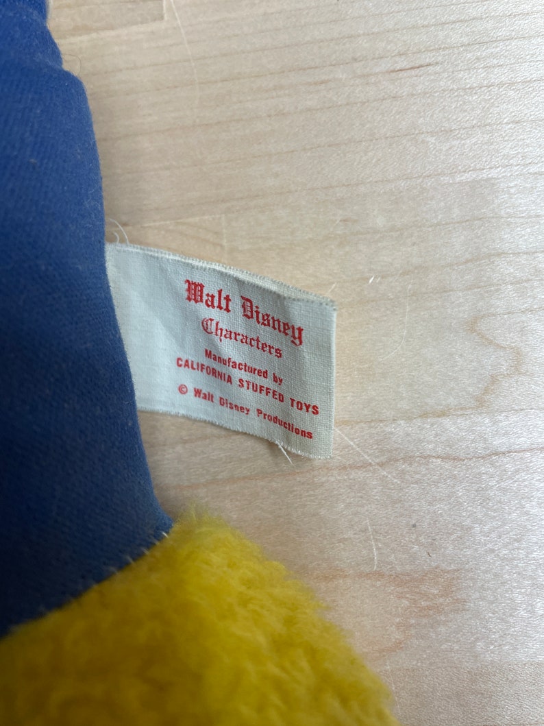 May include: A white tag with red text that reads "Walt Disney Characters Manufactured by California Stuffed Toys &copy; Walt Disney Productions".