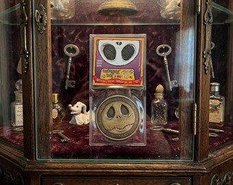 Moneda de la Mansión Embrujada de Disneyland de 2006 con 13 caras de Jack en el monedero.
