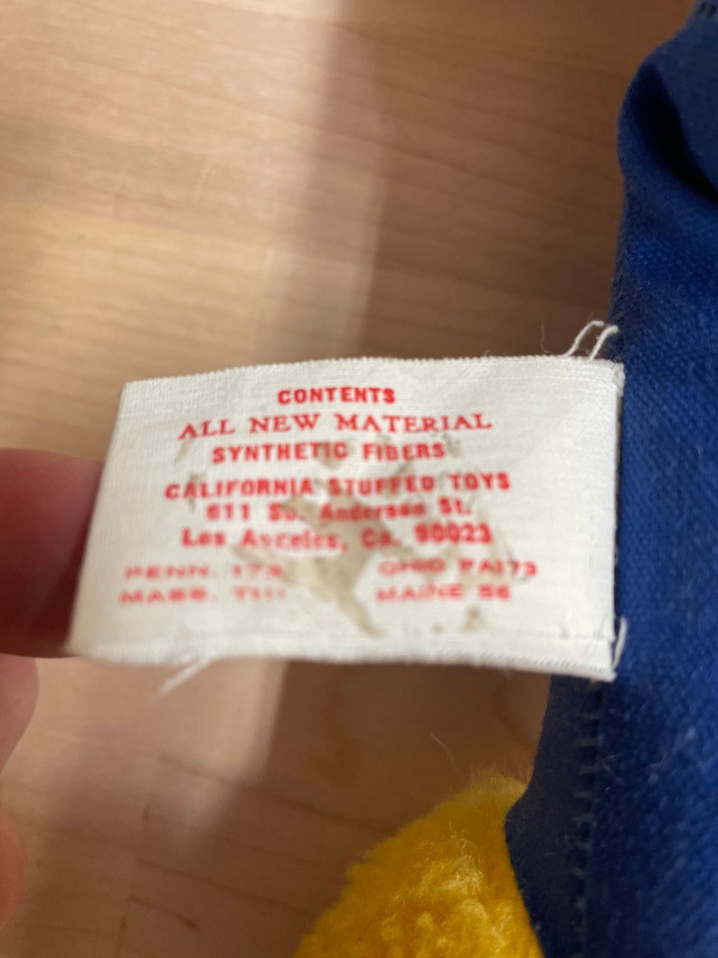 May include: A white tag with red text that reads "CONTENTS ALL NEW MATERIAL SYNTHETIC FIBERS CALIFORNIA STUFFED TOYS 611 So. Andersen St. Los Angeles, Ca. 90023 PENN. 17N OHIO FA173 MADE IN 58"