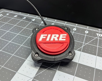May include: A red push button with the word "FIRE" printed in white on it. The button is mounted on a black plastic base with four screws.
