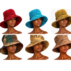 May include: A collection of six bucket hats in various colors including red, blue, yellow, and tan, each featuring a wide brim and a black script pattern printed across the fabric. The hats are displayed on mannequin heads, showcasing the design.