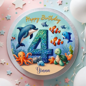 Könnte beinhalten: Ein blauer und grüner Geburtstagskuchen mit einer Nummer 4 darauf. Der Kuchen ist mit einem Delfin, einem Oktopus, einer Schildkröte und Fischen verziert. Der Kuchen sagt "Happy Birthday Ginna" darauf.