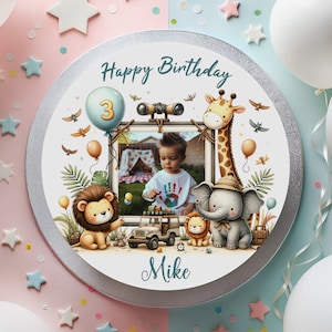 Könnte beinhalten: Runder Kuchen mit silbernem Rand, mit Foto eines Kindes und den Worten "Happy Birthday" und "Mike". Der Kuchen ist mit Zeichentierfiguren, einem Ballon mit der Zahl 3 und einem Safari-Thema verziert.