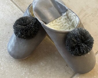 Silver gray lined slippers with gray pompoms.