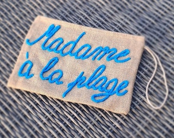 Burlap pouch, embroidered Madame at the beach.