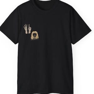 Peut inclure: T-shirt noir avec un imprimé graphique de deux mains faisant le signe de la paix et une personne aux longs cheveux blonds.