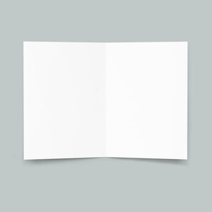 Pu&ograve; includere: Un biglietto bianco vuoto piegato a met&agrave;, con una leggera ombra sotto. Il biglietto &egrave; appoggiato su uno sfondo grigio chiaro.